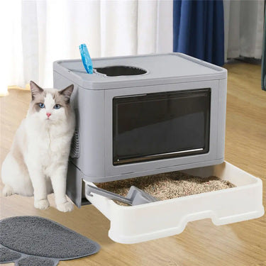 A white and gray cat sits by the KittyNook Cat Co. Purrfect Foldable Litter Solution with dual-entry design.